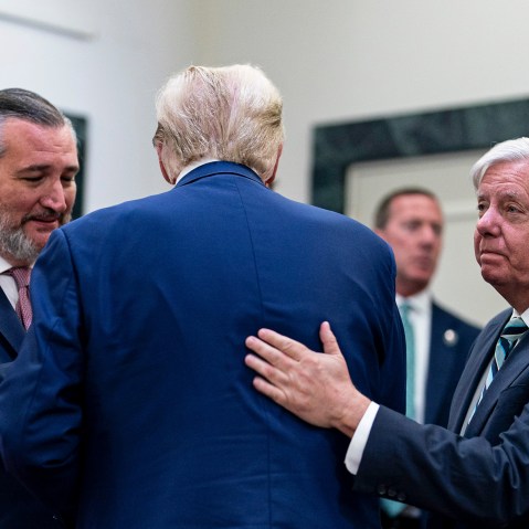 Senator Ted Cruz, left, greets Donald Trump, center, who is facing away from the camera. Lindsey Graham, right, pats Trump on the back.