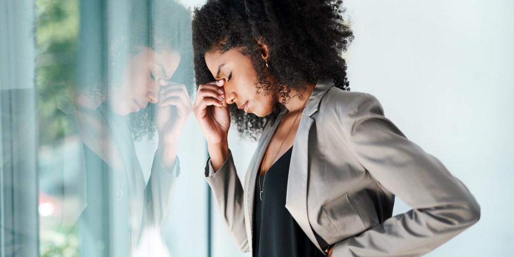 Shot of a young black businesswoman looking stressed out in an office.