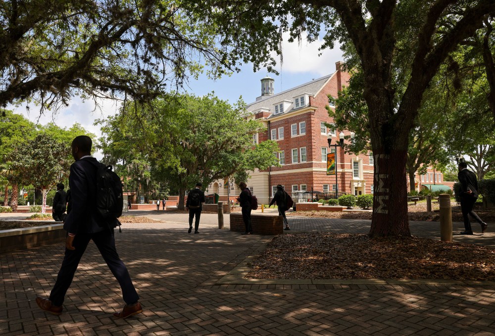 Students in shadow walk in front of Lee Hall at Florida A&M University.