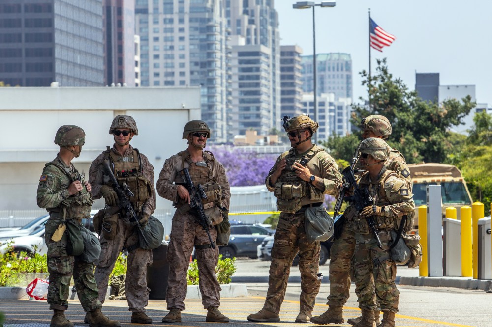 Two U.S. Marines (2nd, 3rd left) stand with California National Guard service members on June 13, 2025 in Los Angeles.