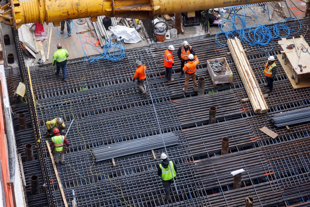 Construction workers are seen from above as they work.