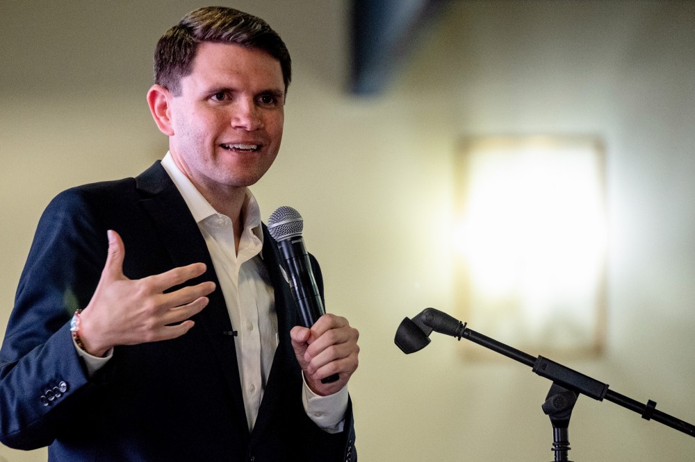 James Talarico speaks while holding a microphone.