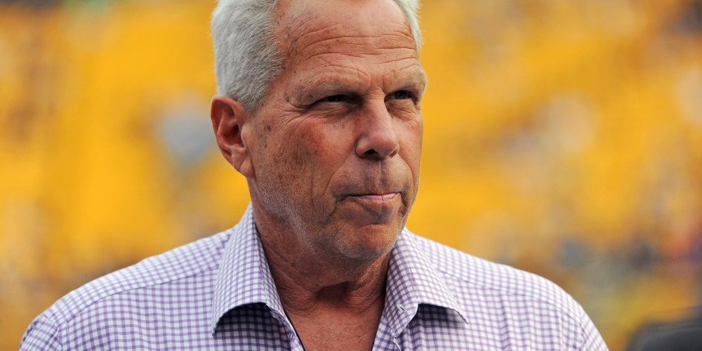 Steve Tisch is seen looking away in this closeup shot in front of a yellow background.