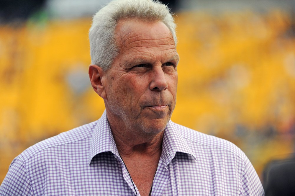 Steve Tisch is seen looking away in this closeup shot in front of a yellow background.