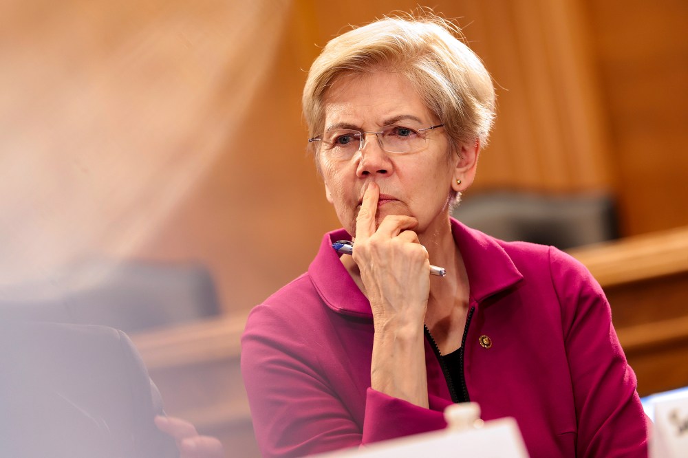 Elizabeth Warren with her finger on her lip, looking confused or deep in thought.