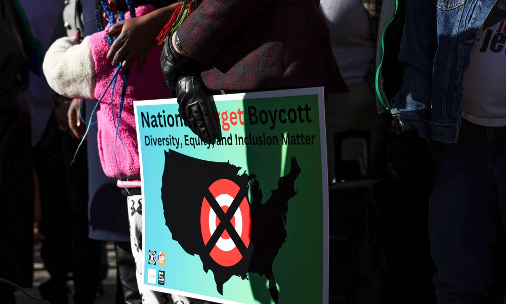 A community member holds a sign calling for a national boycott of Target stores.