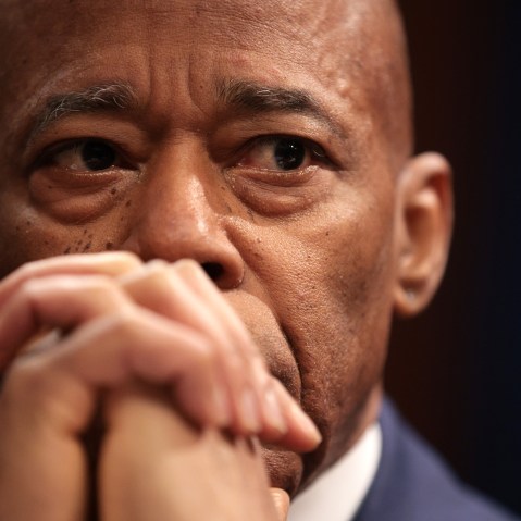 A close up of Eric Adams, whose hands are clasped in front of his mouth.