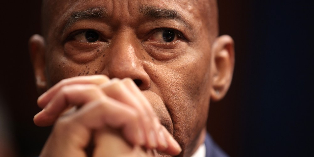 A close up of Eric Adams, whose hands are clasped in front of his mouth.