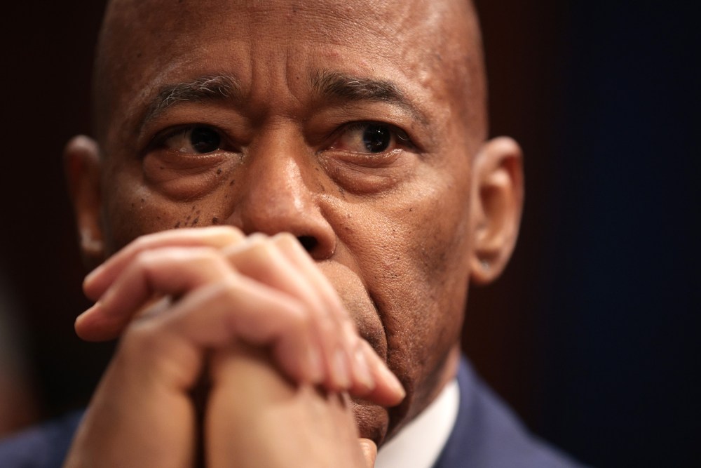 A close up of Eric Adams, whose hands are clasped in front of his mouth.