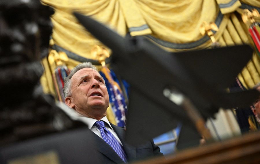 Steve Witkoff speaks in the Oval Office, seen in focus behind a statue of a jet in the foreground.