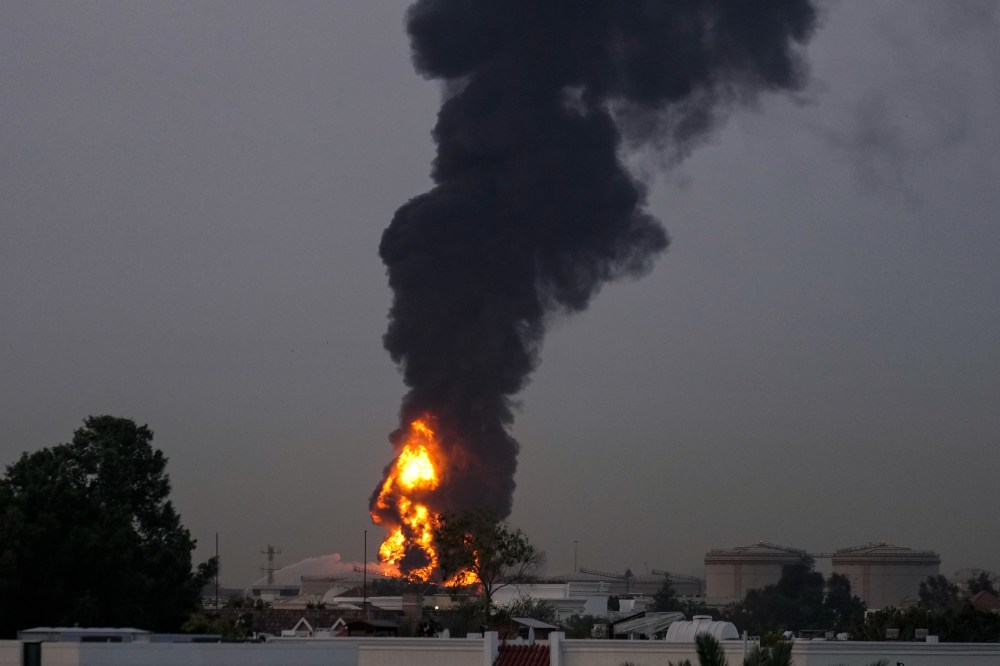 Fire and plumes of smoke rises after s drone struck a fuel tank forcing the temporary suspension of flights.