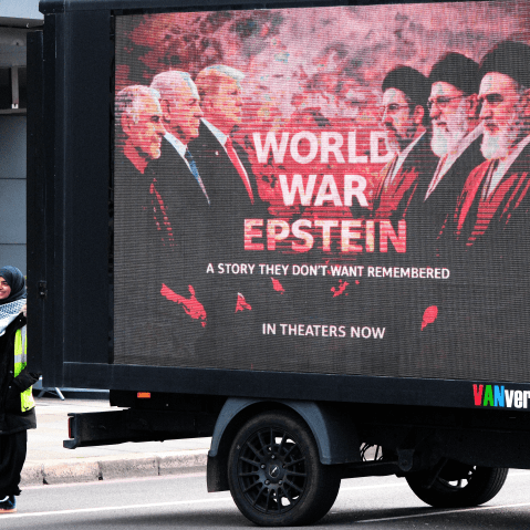 A woman stands next to a sign that reads WORLD WAR EPSTEIN at last weekend's Al Quds Day protest in London.