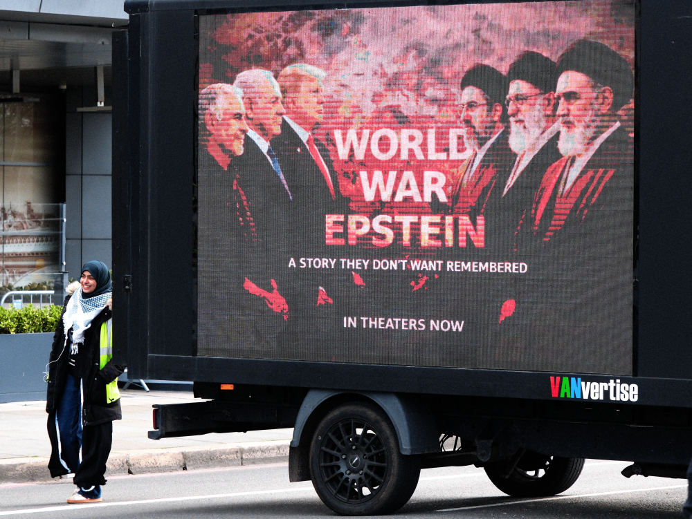 A woman stands next to a sign that reads WORLD WAR EPSTEIN at last weekend's Al Quds Day protest in London.